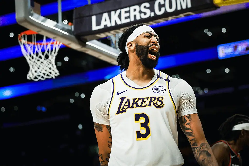 Philadelphia-76ers vs Los Angeles Lakers Picks and Predictions January 28th 2025 3 A Los Angeles Lakers player wearing a white jersey stands on the court, with a basketball hoop and team branding visible in the background.