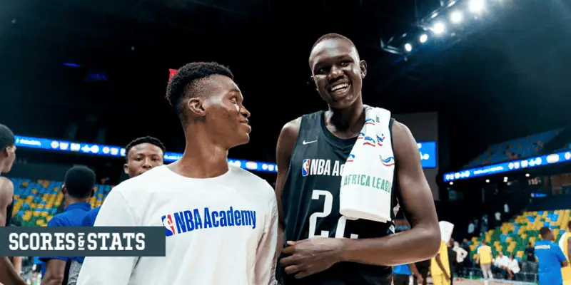 Duke Blue Devils vs Notre Dame Fighting Irish Picks and Predictions January 11th 2025 2 Two NBA Academy players smiling and talking after a game, one wearing a white shirt and the other in a black jersey with an Africa League towel over his shoulder.