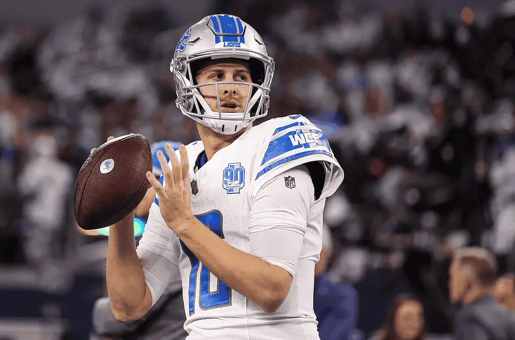 Detroit Lions vs Washington Commanders Picks and Predictions January 18th 2025 3 A poised quarterback from the Detroit Lions prepares to throw a football during a game, wearing a white jersey with blue accents.