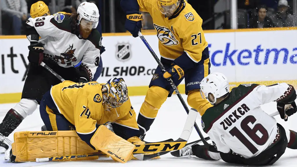Nashville Predators vs Vancouver-canucks Picks and Predictions January 29th 2025 2 NHL players compete for the puck on the ice; a goalie makes a save while opposing players battle for control in an intense moment.