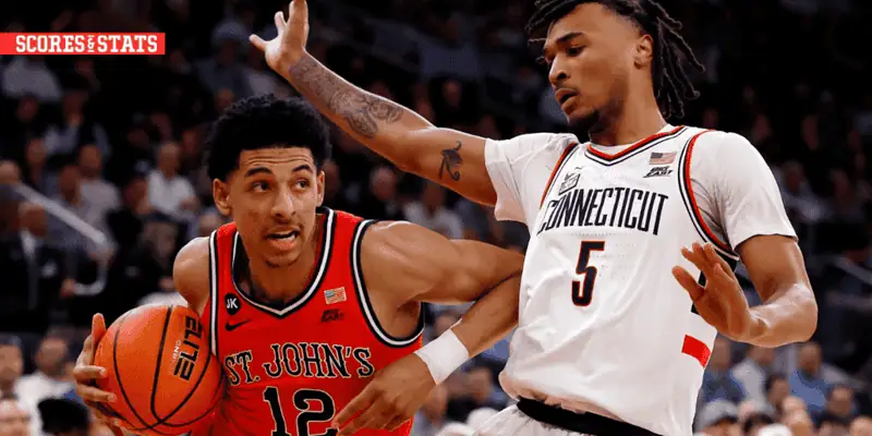 Xavier Musketeers vs St. John's Red Storm Picks and Predictions January 7th 2025 2 St. John's player drives to the basket while being closely guarded by a Connecticut defender during an intense college basketball matchup.