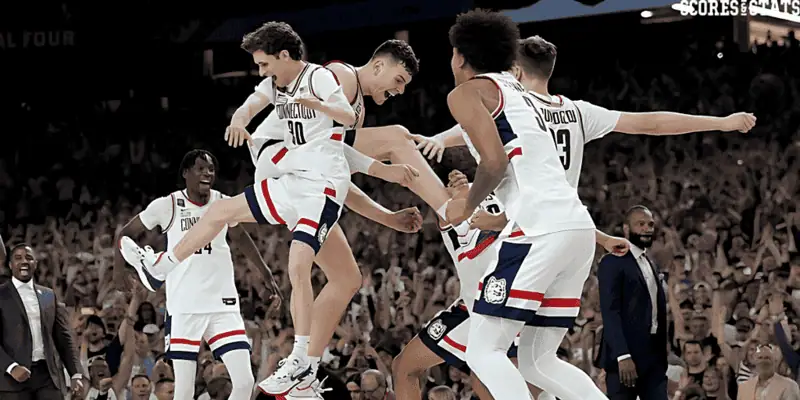 Uconn Huskies vs Providence Fiar Picks and Predictions January 5th 2025 3 UConn Huskies men's basketball team players jump and cheer in celebration during the NCAA Final Four