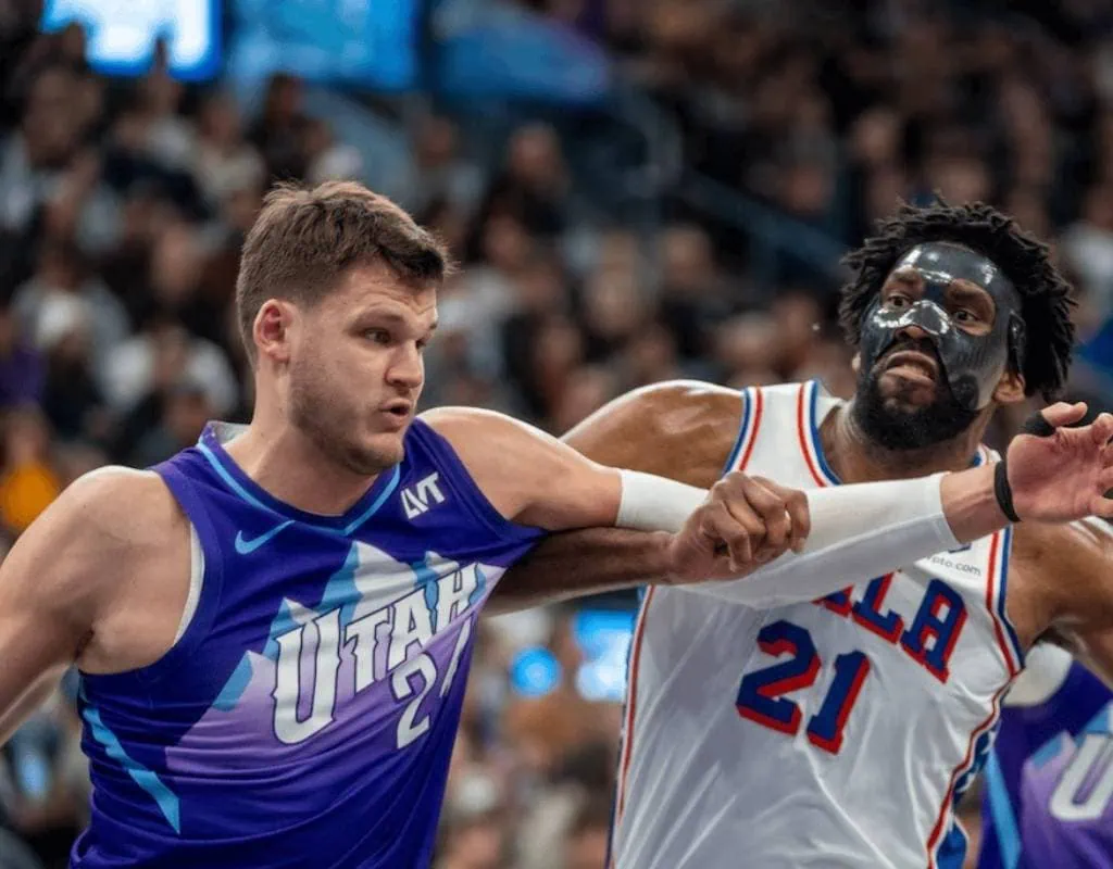 Denver Nuggets vs Philadelphia-76ers Picks and Predictions January 21st 2025 2 A high-intensity basketball game featuring two players in action, one in a blue Utah jersey and the other in a red and white Philadelphia jersey.