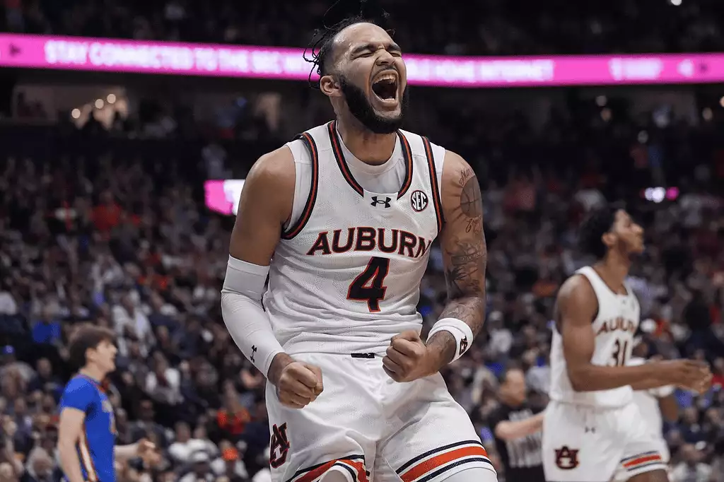 Kentucky Wildcats vs Auburn Tigers Picks and Predictions March 1st 2025 2 Basketball player celebrates with a determined expression after making a pivotal play during a game, surrounded by an excited crowd.