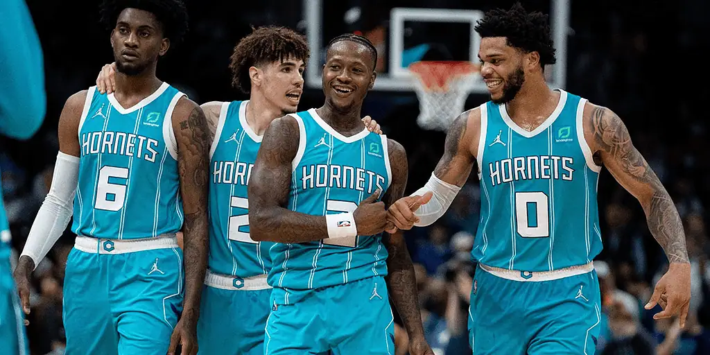 Brooklyn Nets vs Charlotte Hornets Picks and Predictions February 10th 2025 2 Four basketball players in teal Hornets jerseys celebrate on the court, showcasing team spirit and camaraderie during a game.