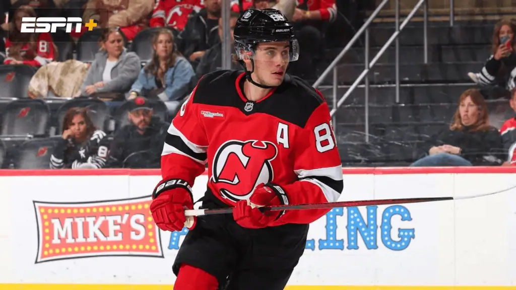 Nashville Predators vs New Jersey Devils Picks and Predictions February 23rd 2025 2 A New Jersey Devils player in a red jersey with the captain's "A" skates on the ice, showcasing a dynamic hockey play.