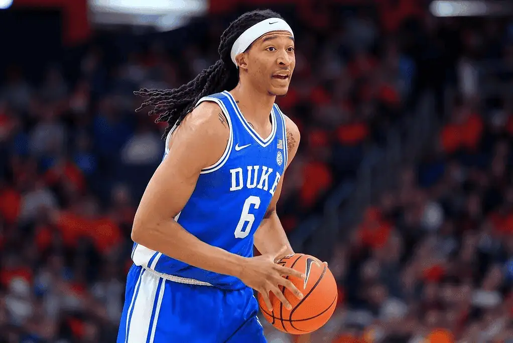 Duke Blue Devils vs Florida State Seminoles Picks and Predictions March 1st 2025 2 A basketball player wearing a Duke jersey holds a ball, poised for action on the court during a game. The crowd is visible in the background.