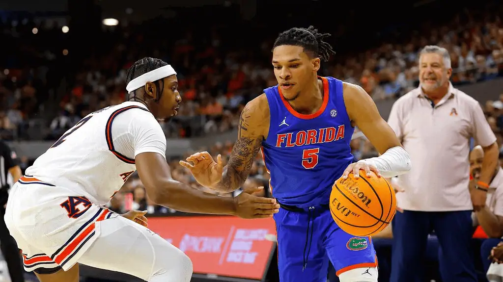 Mississippi State Bulldogs vs Florida Gators Picks and Predictions February 11th 2025 3 A Florida player dribbles the basketball while being closely guarded by an opponent in a competitive college basketball game.