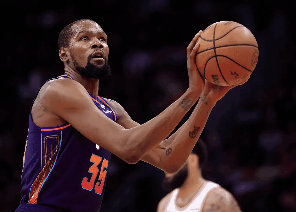 Kevin Durant, wearing a Phoenix Suns uniform with number 35, focuses intensely while preparing to shoot a free throw during a game.