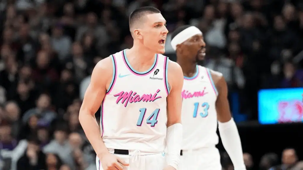 Milwaukee Bucks vs Miami Heat Picks and Predictions February 23rd 2025 3 Two basketball players in Miami Heat jerseys celebrate on the court during a game, surrounded by a cheering crowd.
