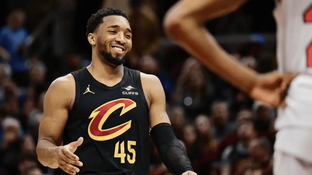 Cleveland-cavaliers vs Memphis Grizzlies Picks and Predictions February 23rd 2025 2 A basketball player in a black jersey with "Cavs" logo gestures during a game, surrounded by spectators in the background.