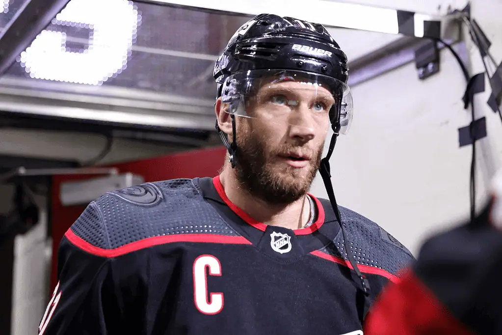 Carolina Hurricanes vs Buffalo Sabres Picks and Predictions February 27th 2025 2 A hockey player wearing a black and red jersey with a letter "C," standing in a tunnel, preparing to enter the rink.