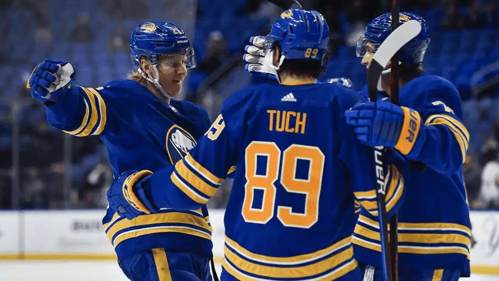 Buffalo Sabres vs New Jersey Devils Picks and Predictions February 2nd 2025 2 Players in blue hockey jerseys celebrate a goal on the ice rink, showcasing teamwork and excitement