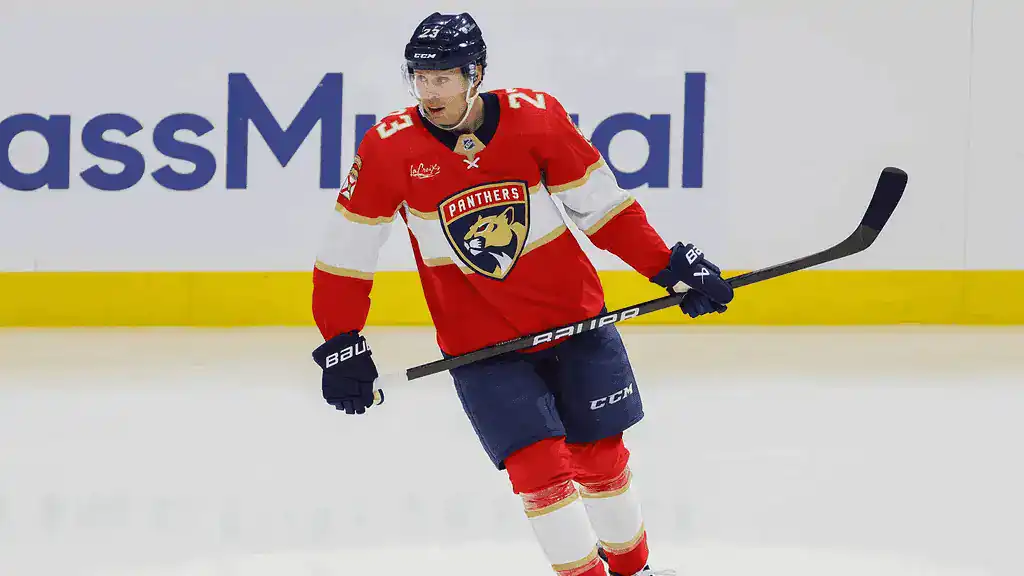 Florida Panthers vs Edmonton Oilers Picks and Predictions February 27th 2025 3 A hockey player in a red Florida Panthers jersey skates on the ice, holding a stick, with team branding visible in the background.