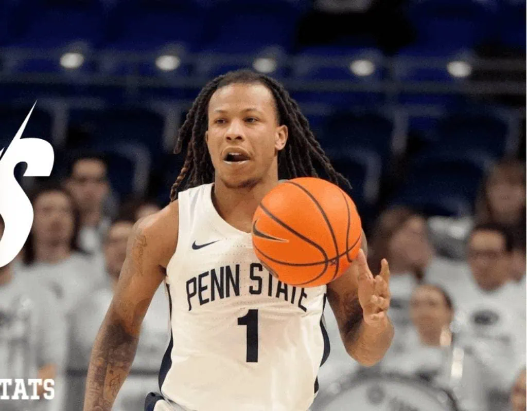 Penn State Nittany Lions vs Nebraska Cornhuskers Picks and Predictions February 19th 2025 2 A basketball player in a Penn State uniform dribbles a ball, with blurred spectators in the background during a game.
