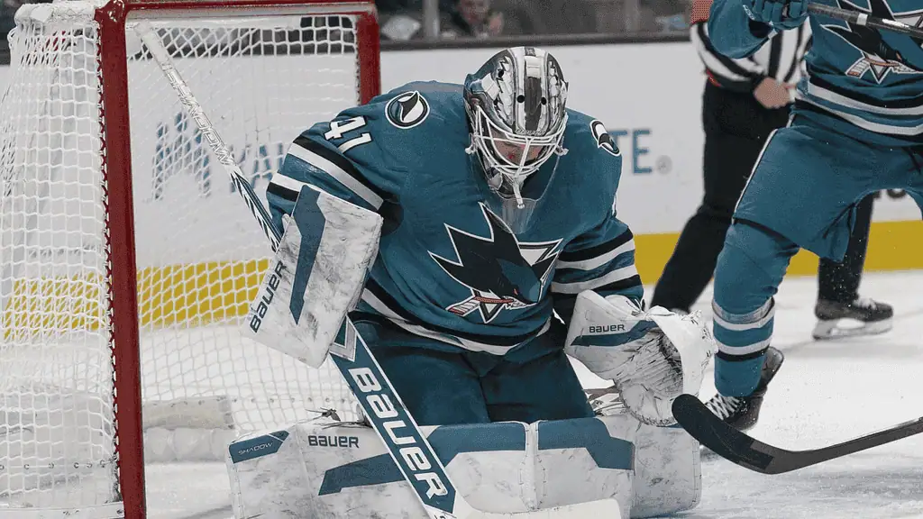 Montréal Canadiens vs San Jose Sharks Picks and Predictions February 27th 2025 3 A hockey goalie in a teal jersey crouches in front of the net, preparing to stop a puck during an intense game.