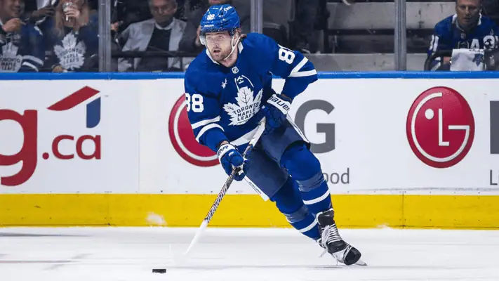 Seattle Kraken vs Toronto Maple Leafs Picks and Predictions February 6th 2025 2 Toronto Maple Leafs hockey player, wearing a blue uniform with number 88, skating on the ice while handling the puck during a game.
