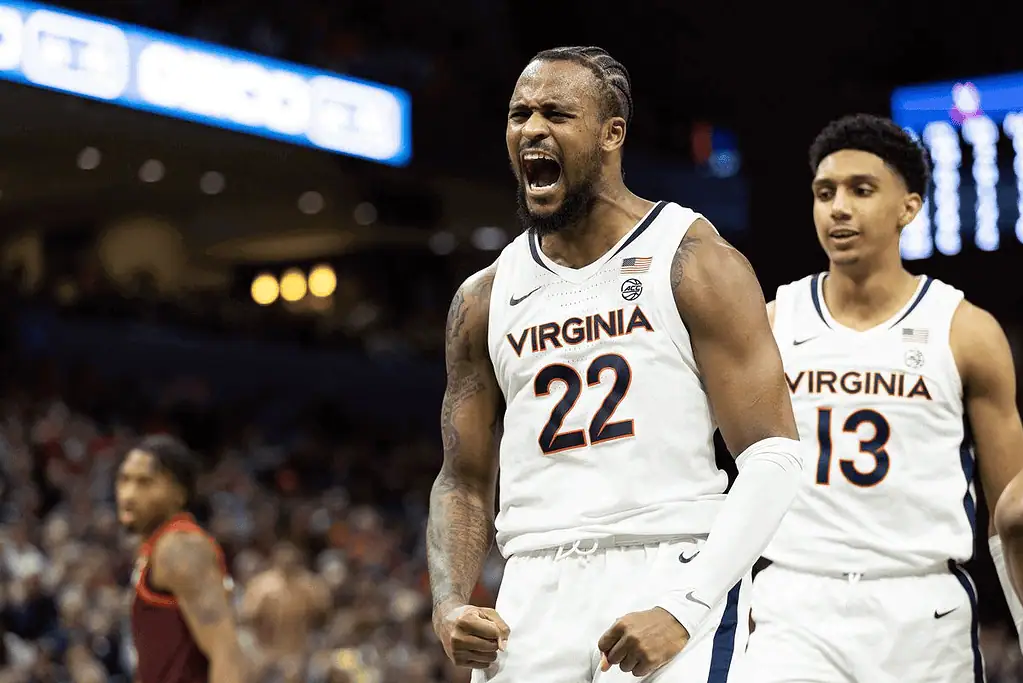Virginia Cavaliers vs Clemson Tigers Picks and Predictions March 1st 2025 3 Two basketball players in Virginia uniforms celebrate on the court during a game, showcasing team spirit and athleticism.
