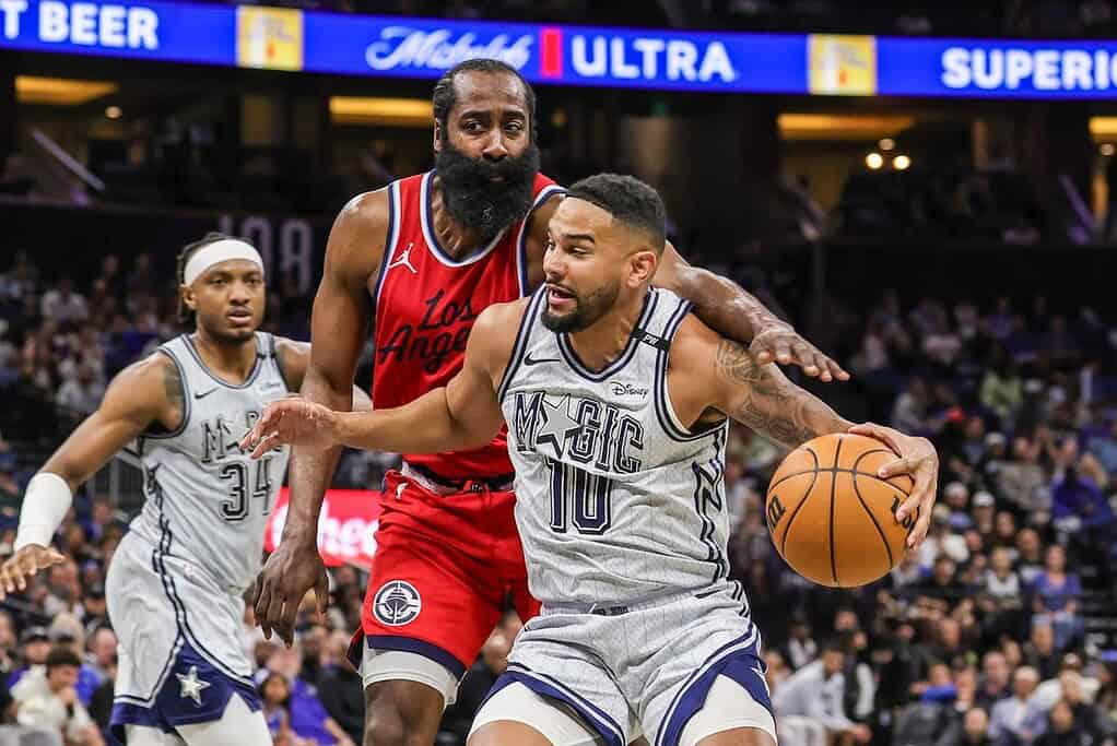 Magic Player Dribbling past James Harden