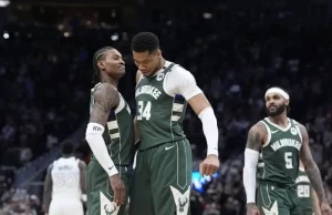 A group of Milwaukee Bucks players celebrate in their green jerseys during a basketball game, showcasing teamwork and excitement.