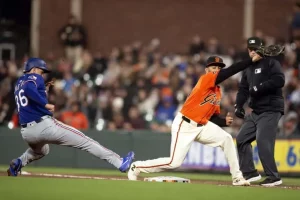 A baseball player slides into base as a fielder attempts to tag him out