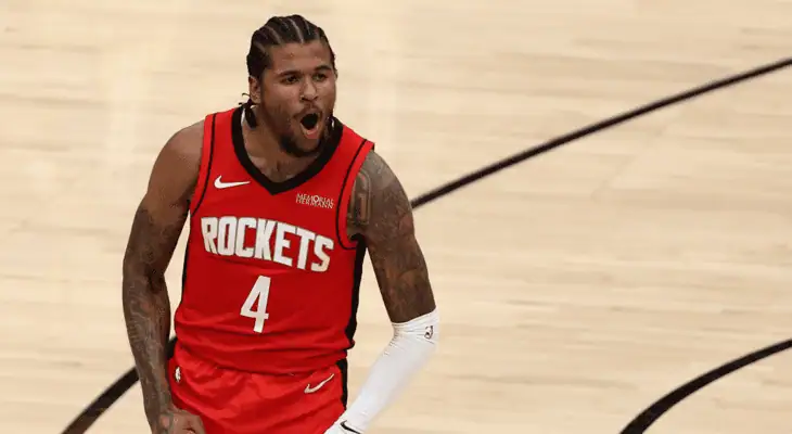 Houston Rockets player (#4) in a red jersey passionately yelling during a game, with clenched fists