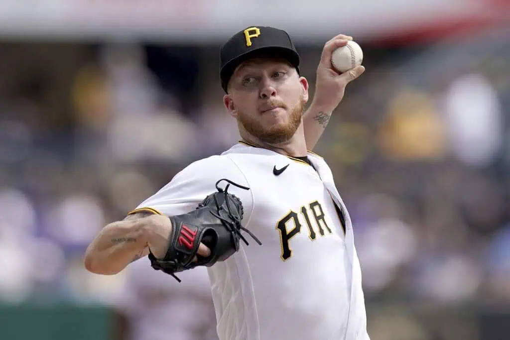 Pittsburgh Pirates vs Milwaukee Brewers Picks and Predictions May 25th 2025 2 A pitcher in a black and yellow uniform throws a baseball during a game, showcasing focus and athleticism amidst a blurred stadium background.
