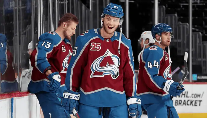 Dallas Stars vs Colorado Avalanche Picks and Predictions May 3rd 2025 2 Smiling Colorado Avalanche player wearing jersey number 95 stands near the bench with teammates during an NHL game.
