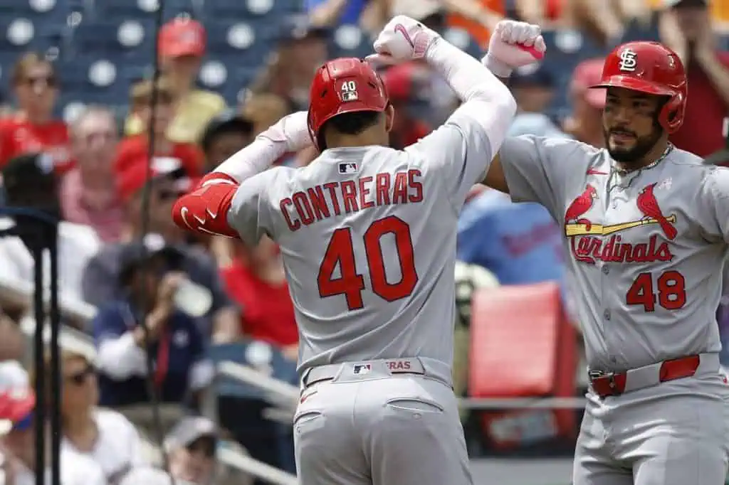 A St. Louis Cardinals player celebrates with teammates after a successful play, wearing a gray jersey with "CONTRERAS" and number 40.