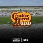 Aerial view of Nashville Superspeedway during the Cracker Barrel 400, featuring race cars on the track and a large crowd in the stands.