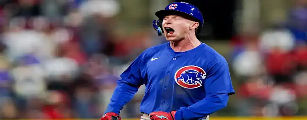 Chicago Cubs player in blue uniform passionately celebrates during a baseball game with helmet and gloves on.
