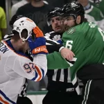 An intense moment in hockey as players grapple, with officials intervening to separate them during a heated game.
