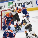 NHL playoff game between the Vegas Golden Knights and Edmonton Oilers with players battling in front of the net during a high-intensity moment.