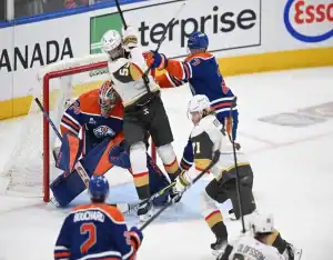 NHL playoff game between the Vegas Golden Knights and Edmonton Oilers with players battling in front of the net during a high-intensity moment.