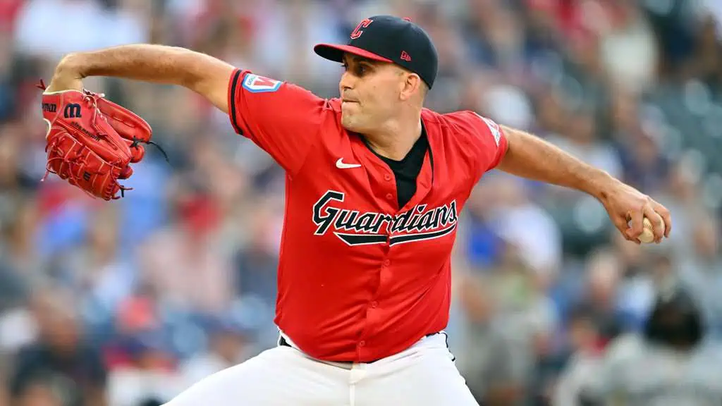 Chicago Cubs vs San Francisco Giants Picks and Predictions May 5th 2025 2 A baseball pitcher in a red Guardians jersey winds up to throw a pitch, showcasing determination in a dynamic stadium setting.