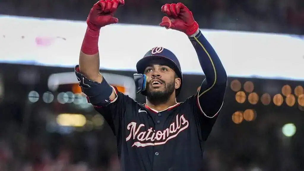 Baltimore Orioles vs Washington Nationals Picks and Predictions May 16th 2025 2 A baseball player in a Nationals jersey raises his arms joyfully, celebrating a play at a night game with lights glowing in the background.