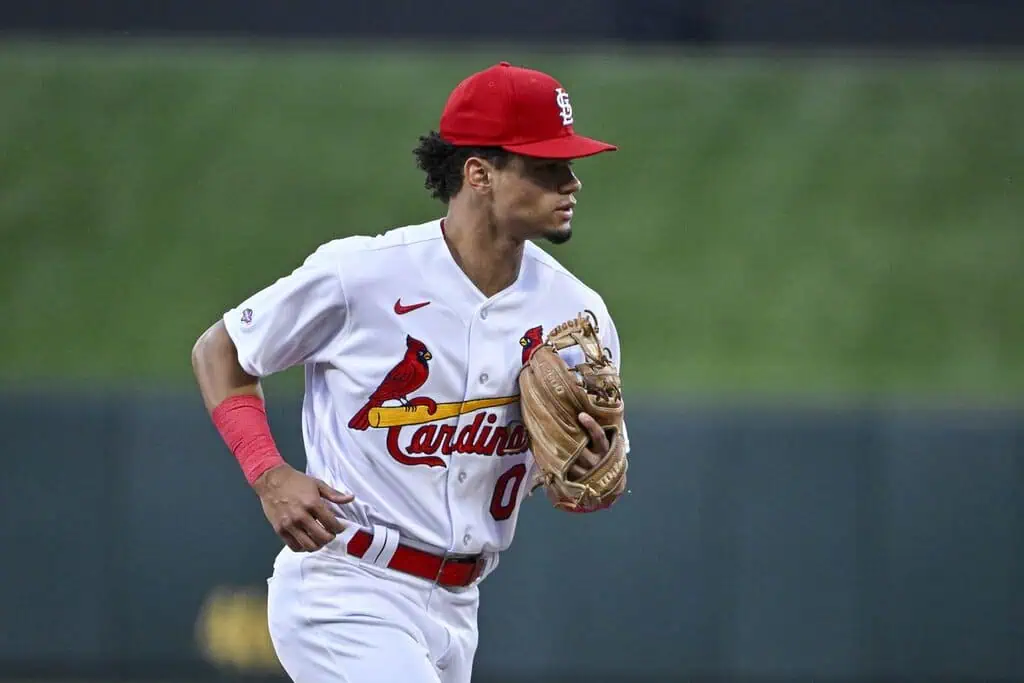 Cincinnati Reds vs St. Louis Cardinals Picks and Predictions May 1st 2025 1 A young baseball player in a white Cardinals uniform runs with a glove, ready to make a play on the field.