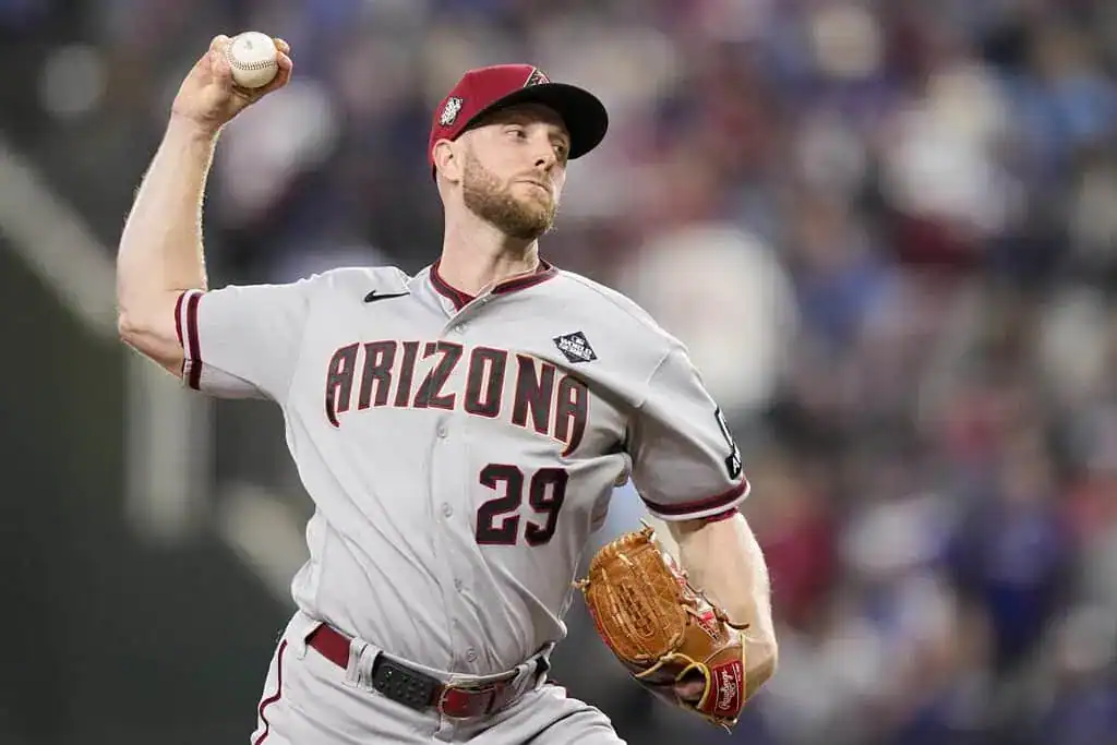 Arizona Diamondbacks vs Washington Nationals Picks and Predictions May 30th 2025 2 A baseball player in a gray Arizona uniform winds up to pitch, gripping a baseball, with fans and stadium blurred in the background.