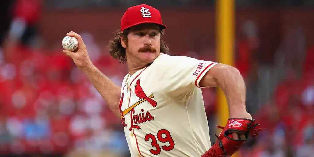 St. Louis Cardinals vs Pittsburgh Pirates Picks and Predictions May 5th 2025 2 A baseball player in a white St. Louis Cardinals jersey winds up to pitch on a vibrant game day, with fans in the background.