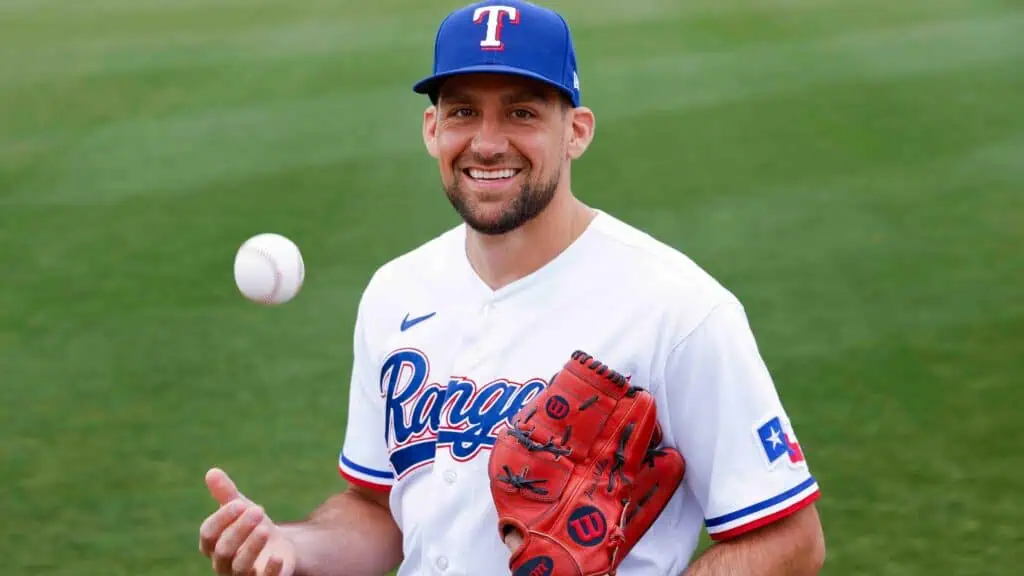 Boston Red Sox vs Texas Rangers Picks and Predictions May 6th 2025 2 A baseball player in a Texas Rangers uniform tosses a baseball in the air on a grassy field, ready for practice.
