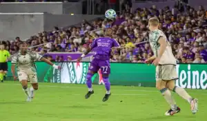 Orlando City player heads the ball against Atlanta United defenders