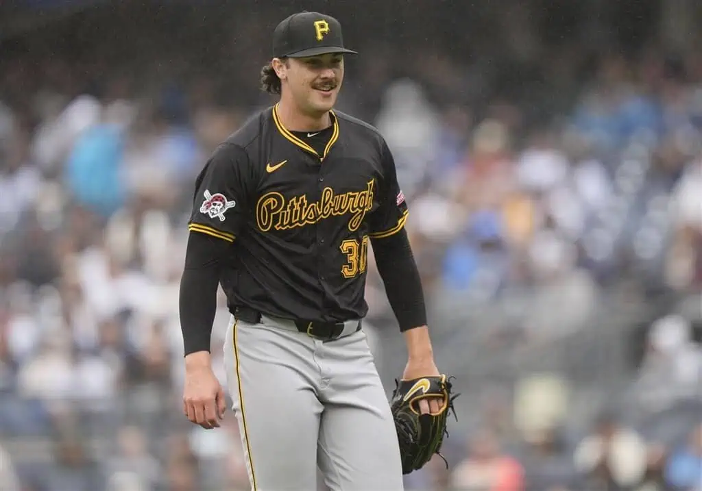 St. Louis Cardinals vs Pittsburgh Pirates Picks and Predictions May 6th 2025 2 A pitcher in a black Pittsburgh Pirates jersey, wearing gray pants, stands on the mound at a baseball stadium during a game.