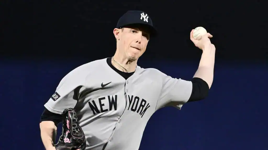 Los Angeles Angels vs New York Yankees Picks and Predictions May 27th 2025 2 A New York Yankees pitcher in a gray uniform is winding up to throw a baseball during a game. The background is dark.