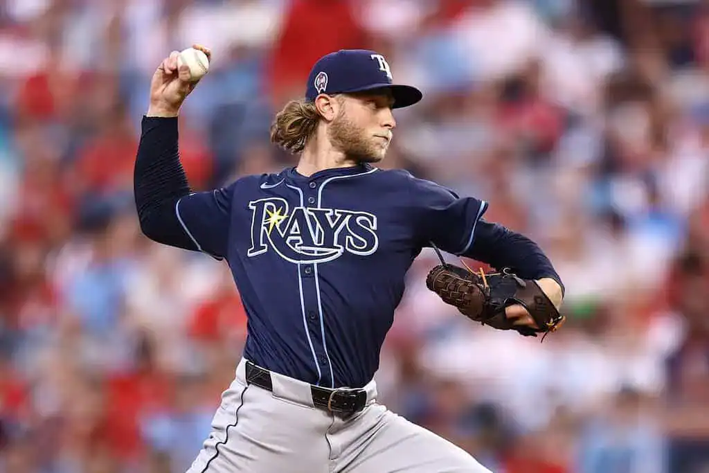 Houston Astros vs Tampa Bay Rays Picks and Predictions May 29th 2025 2 A pitcher in a Tampa Bay Rays uniform winds up to throw a baseball, showcasing an intense moment on the field with a blurred crowd behind.