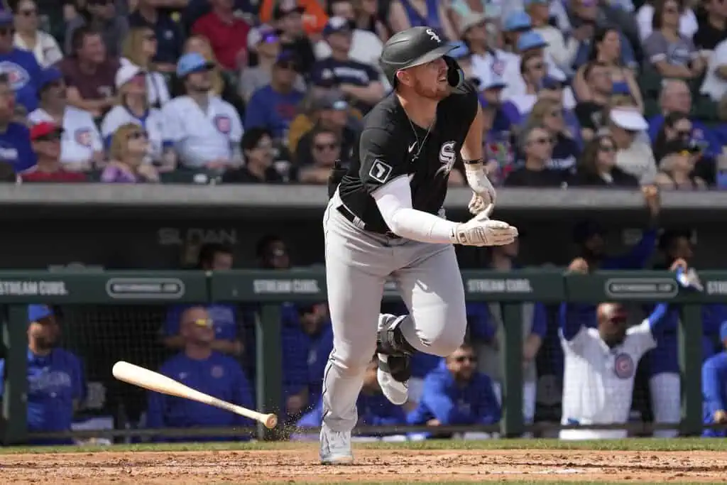 Chicago Cubs vs Miami Marlins Picks and Predictions May 12th 2025 2 A baseball player in a black jersey runs towards first base after hitting the ball, with excited fans in the background.