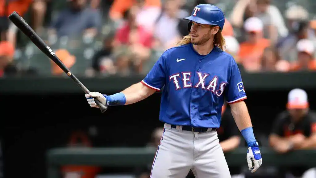 Miami Marlins vs Tampa Bay Rays Picks and Predictions May 16th 2025 2 A baseball player in a blue Texas Rangers jersey adjusts his grip on a bat, standing in a stadium filled with spectators.