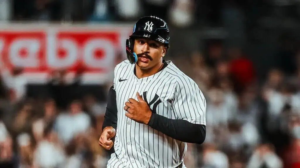 New York Yankees vs San Diego Padres Picks and Predictions May 6th 2025 2 A baseball player wearing a striped Yankees jersey jogs on the field, with a stadium crowd blurred in the background.