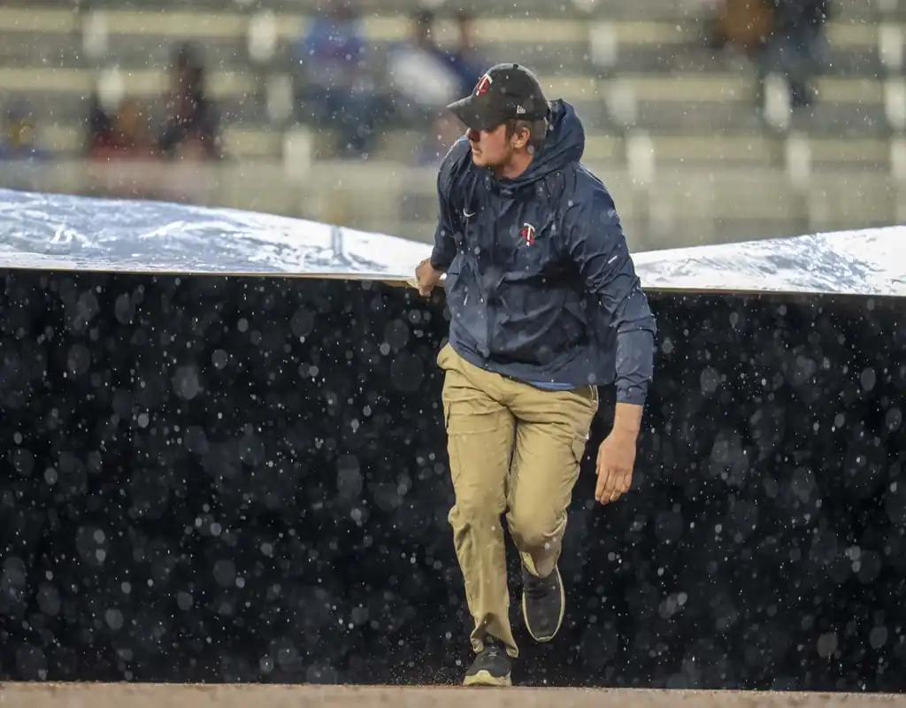 Minnesota Twins grounds crew member pulls tarp over field during rain delay on May 21, 2025.