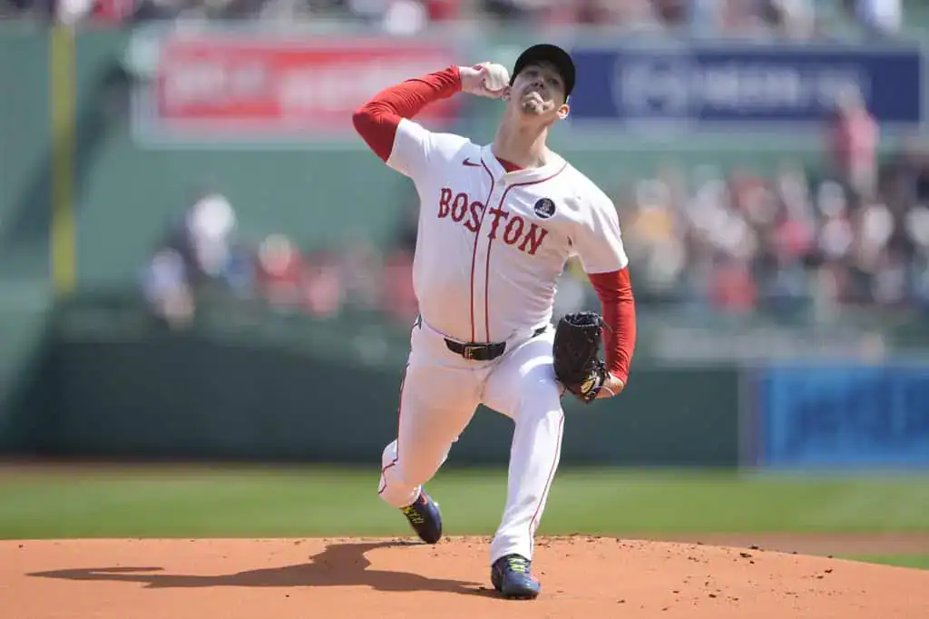 Boston Red Sox vs Baltimore Orioles Picks and Predictions May 25th 2025 2 A pitcher in a white Boston jersey throws a baseball, with a vibrant crowd and green stadium backdrop.