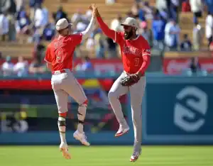 Los Angeles Angels players celebrate with a high-five during a game against the Oakland Athletics on May 19, 2025